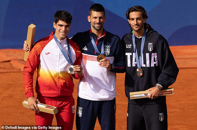 Alcarez pictured (left) alongside Djokovic (centre) and bronze medalist Lorenzo Musetti (right)